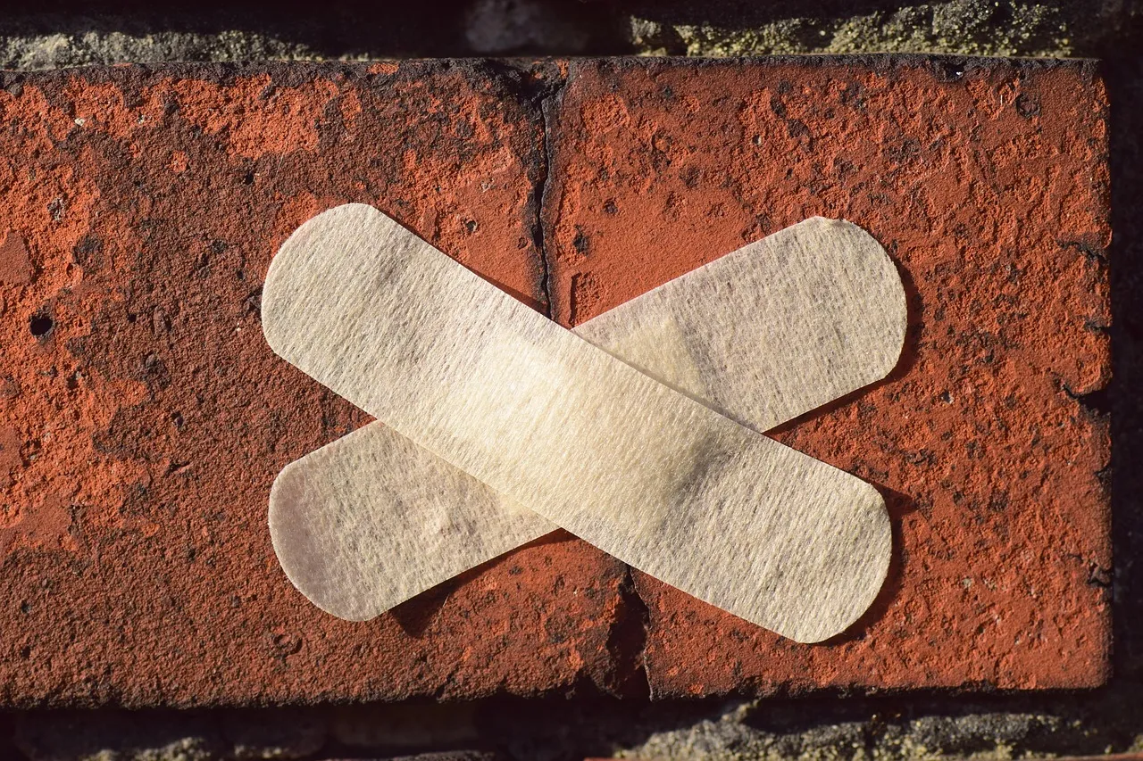 Close-up of home exterior showing foundation crack and siding separation indicating settling