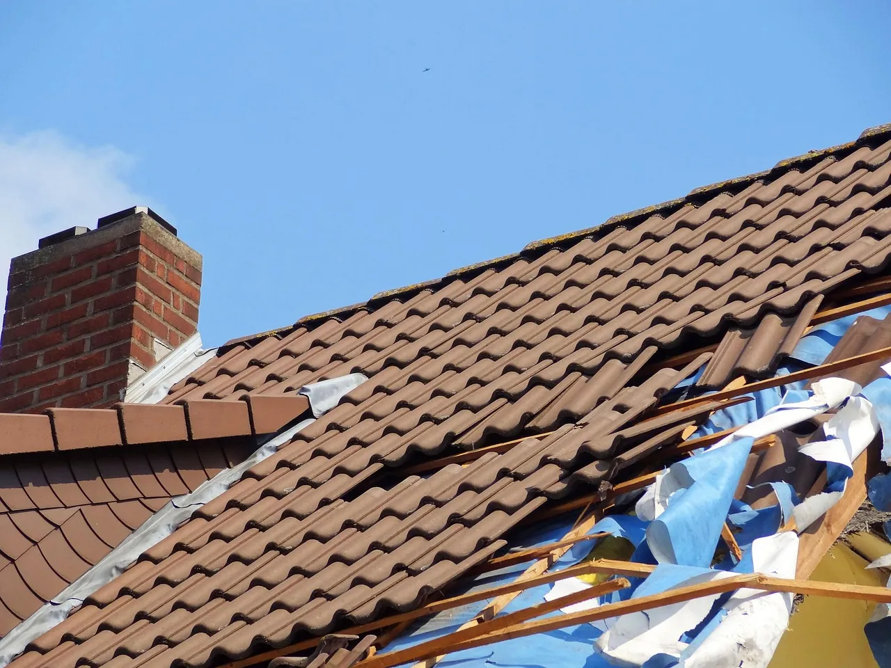 Storm-damaged townhome community roof and siding showing hail and wind impact