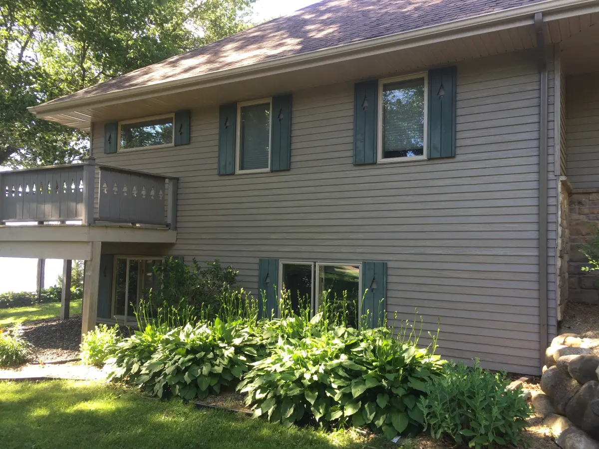 Minnesota home with older windows and shutters showing signs of aging - window replacement assessment by Weatherguard Construction