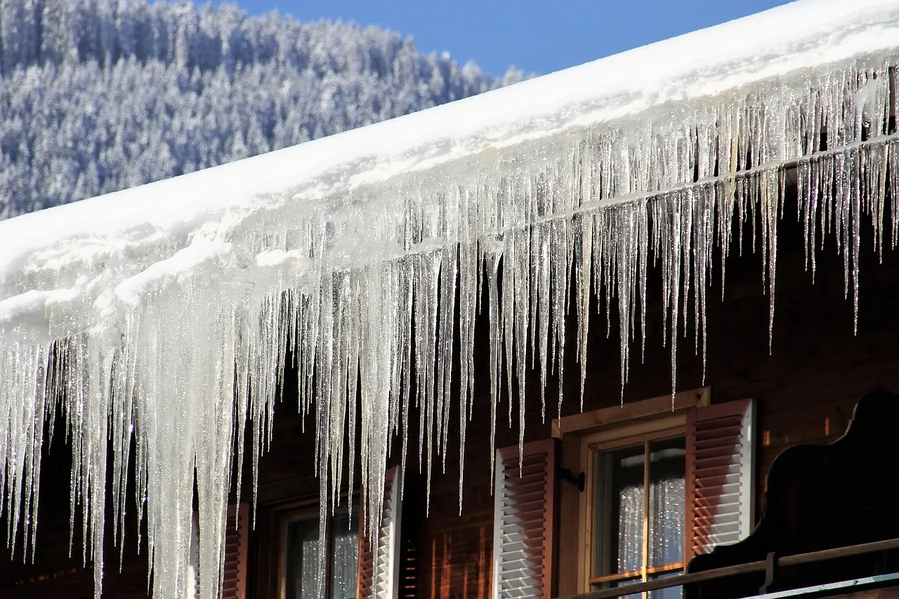 Ice dams and icicles forming on Minnesota home gutters during winter showing common cold weather problems